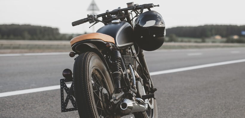 custom motorcyle parked on road with insurance