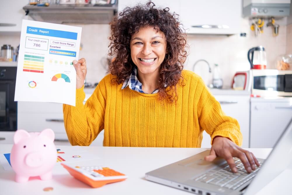 Happy woman checking her good credit score online, improved her credit score by bundling her insurance.