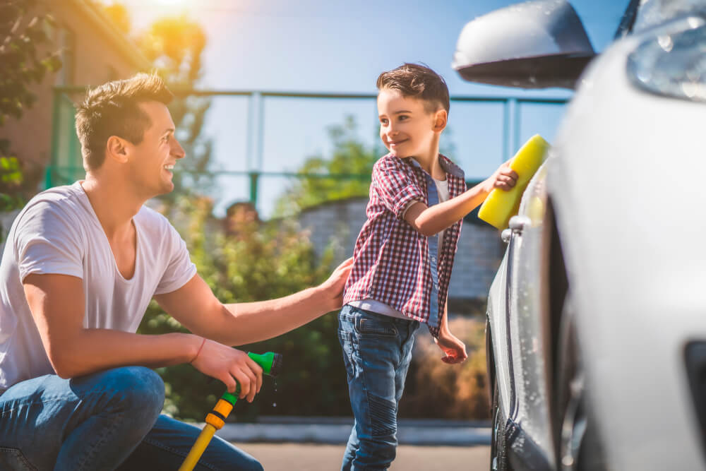 Father and son wash the car, making sure he has the right amount of insurance.
