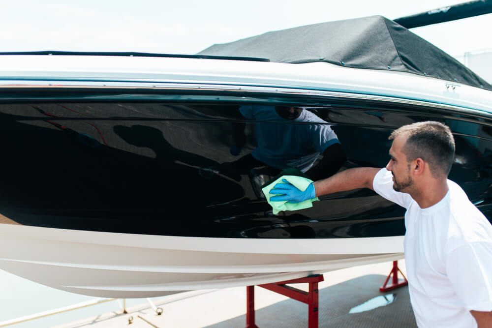 Man polishing his boat in preparation for the summer boating season.