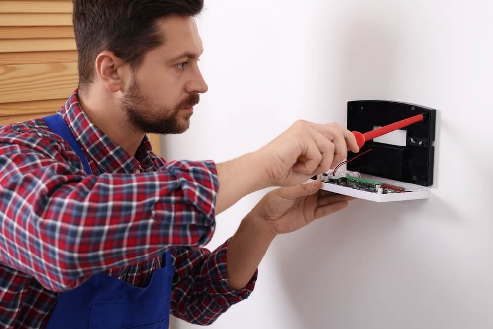 Technician installing a home security system.