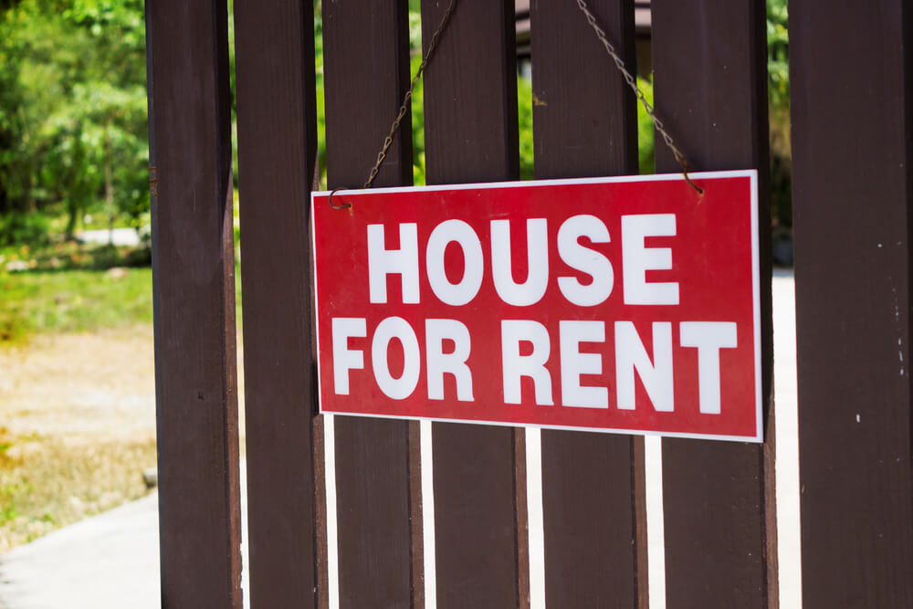 A house for rent sign on a fence - best landlord insurance.