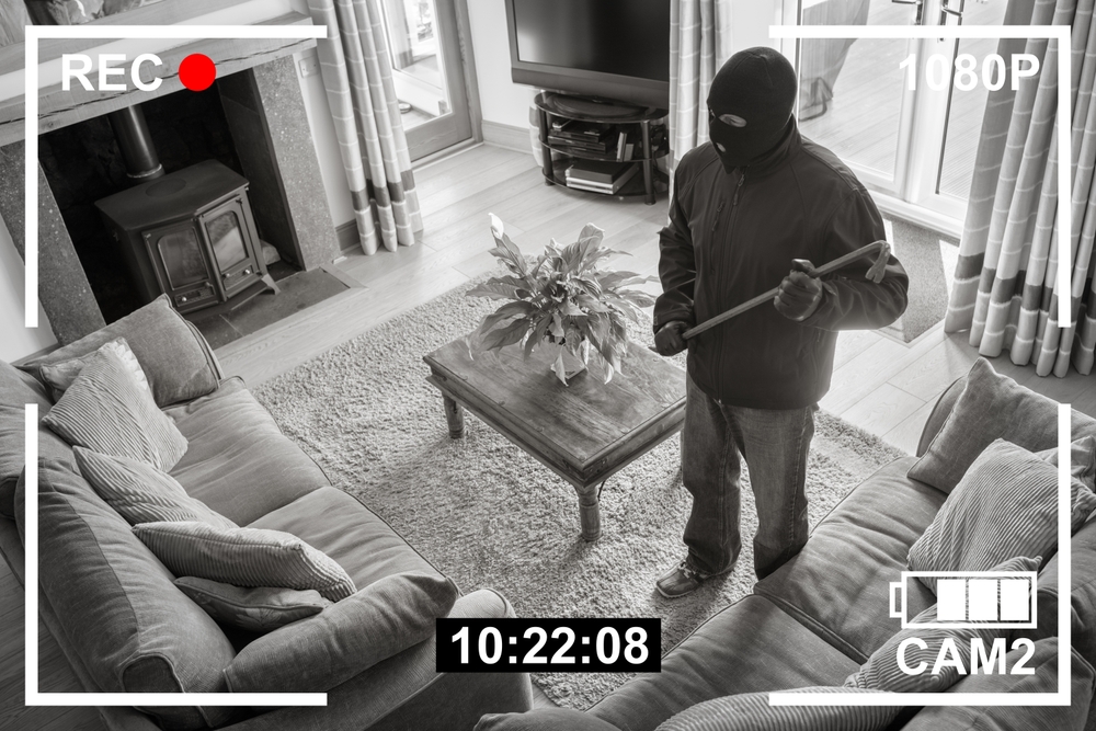 Burglar in the living room with mask on and crow bar - renters insurance