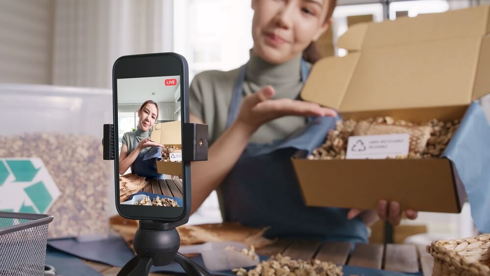 Woman with home-based business showcasing her products in a live stream