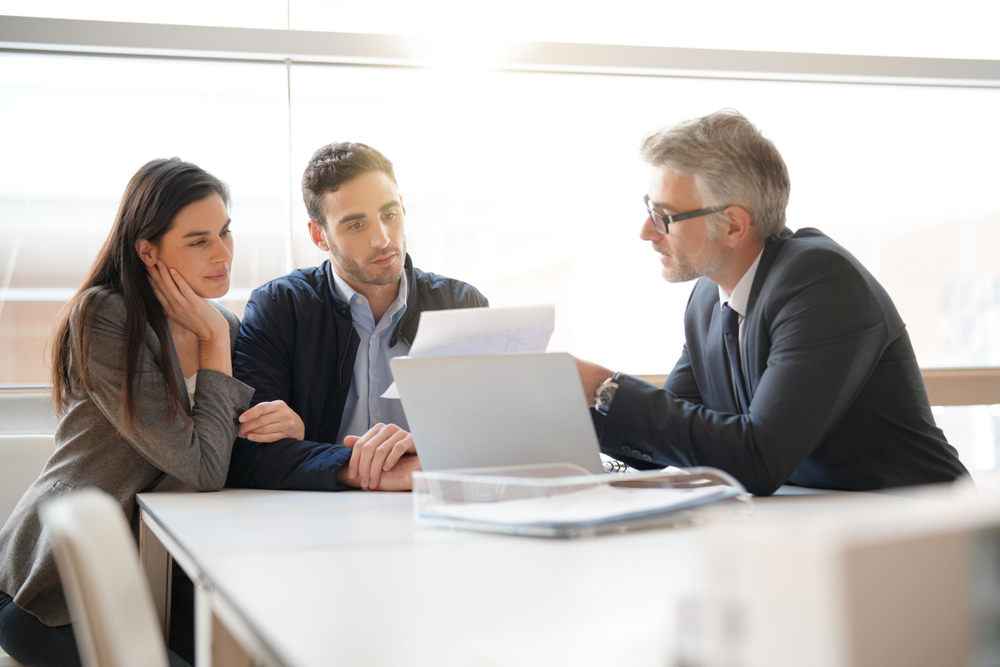Millennial couple works with male insurance agent - best quality car insurance