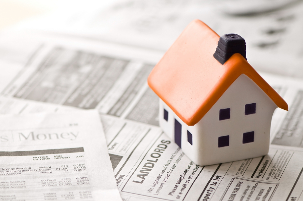 Concept of landlord insurance with small home sitting on landlord contracts