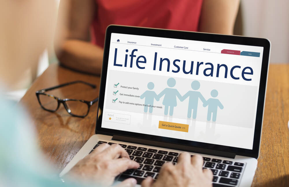 Hands on laptop looking up life insurance options.