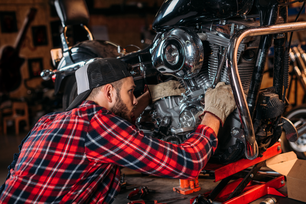 Man works on motorcycle maintenance