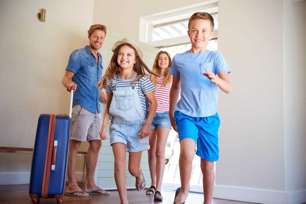 Family Arriving At Summer Vacation Rental.