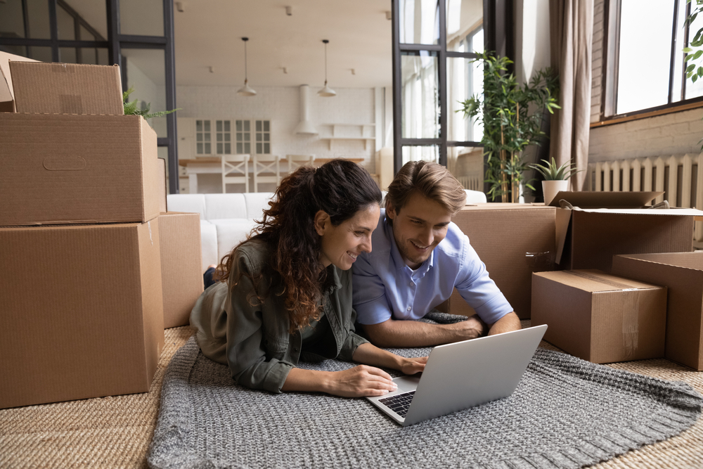 Millenial couple in their new rental space search online for affordable renters insurance.