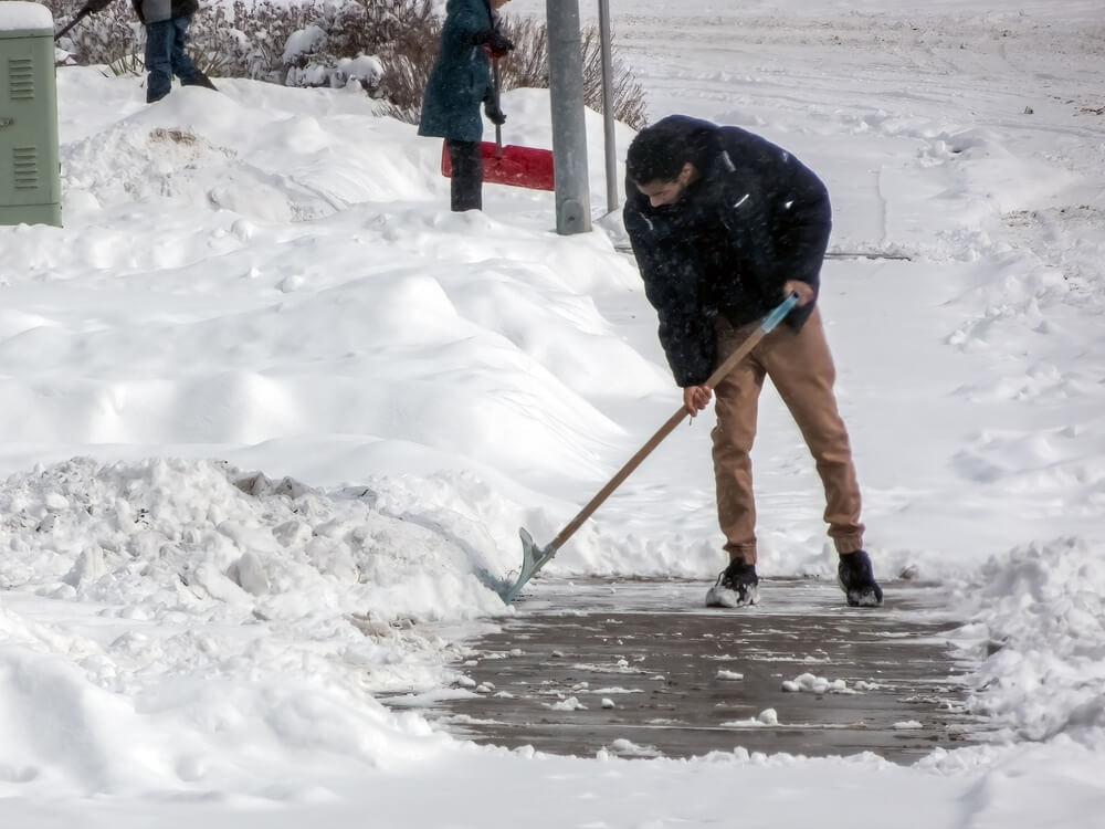 Black man shoveling snow.