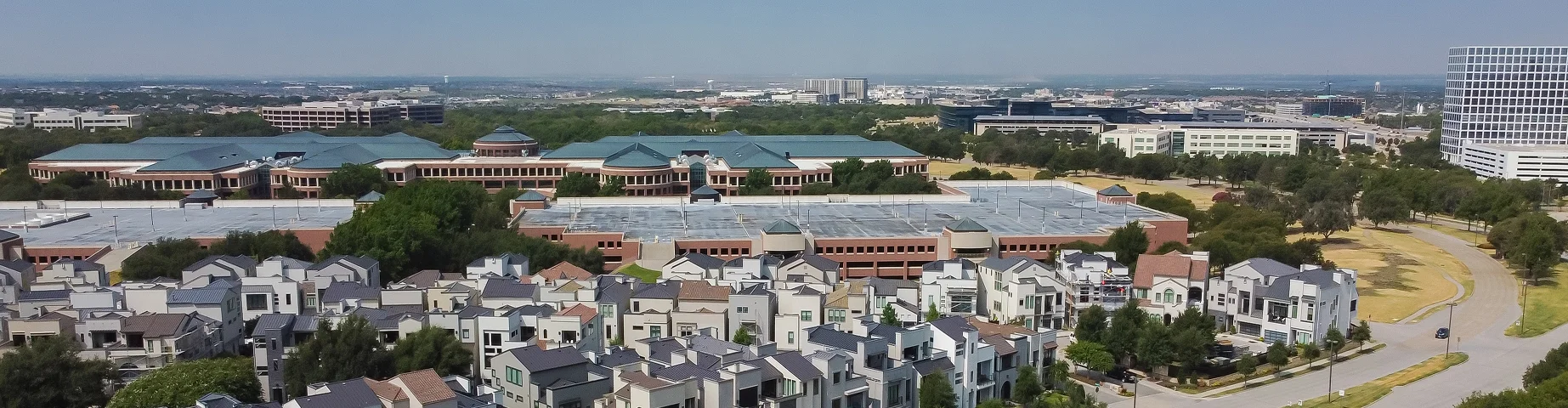 Row of luxury multistory villas upscale residential houses at the intersection of Headquarters and Preserve Street in Legacy West, Plano - best car insurance in Texas.