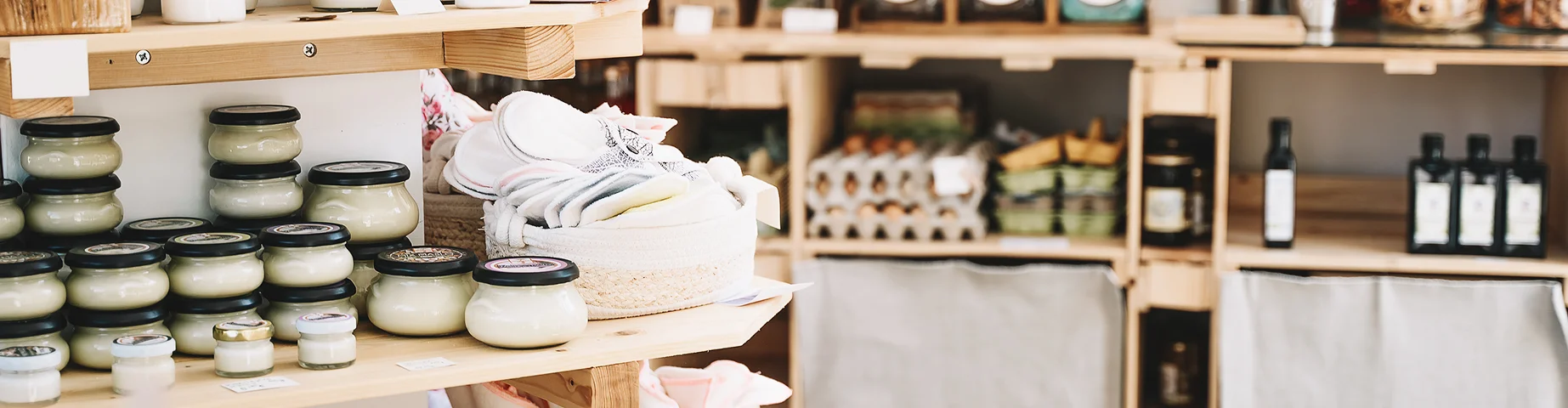 Wooden shelves with different food goods and personal hygiene or cosmetics products in plastic free grocery store – best business insurance.